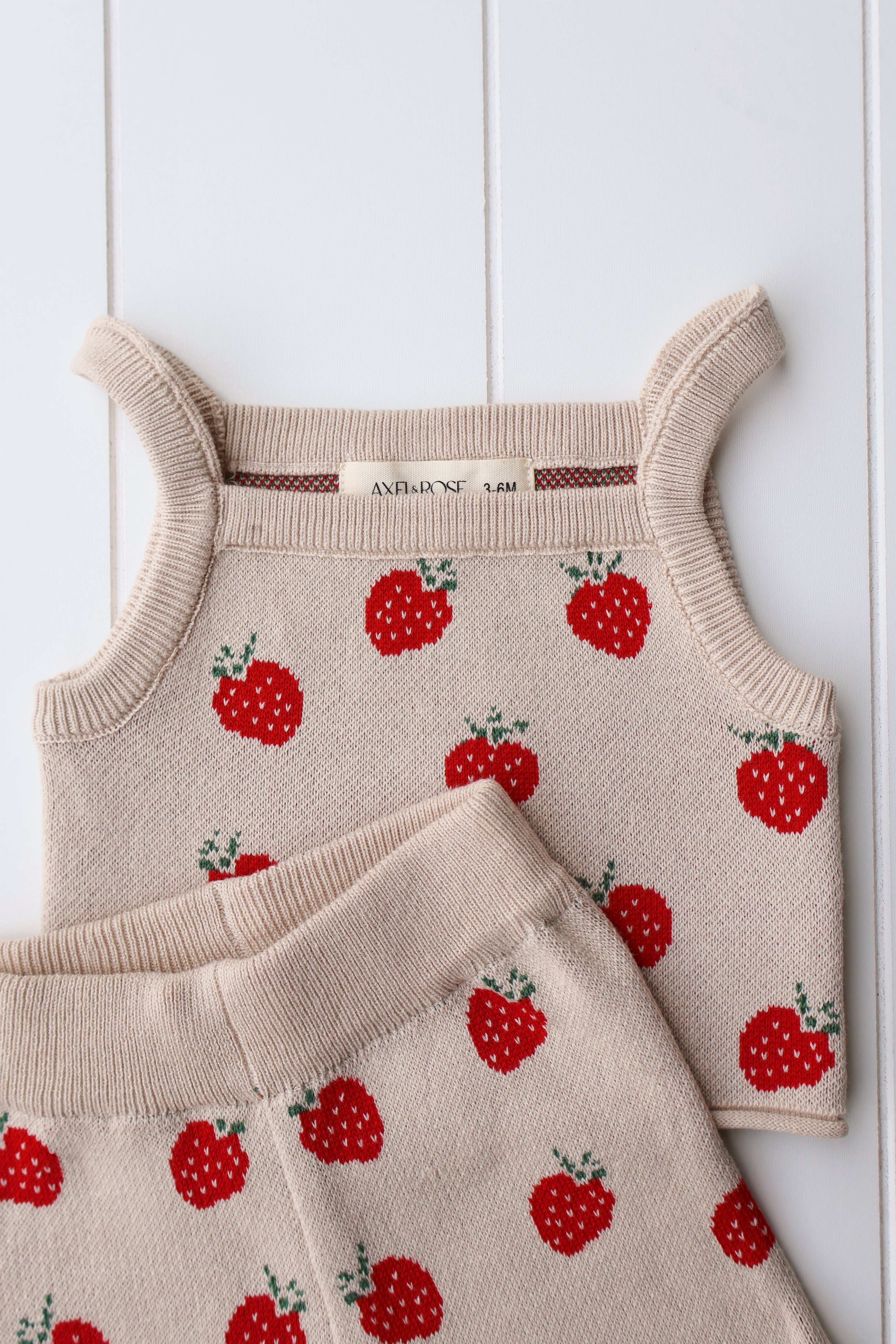 Spring knit strawberry two-piece set for baby girl, featuring soft cotton-blend fabric and cute strawberry print.