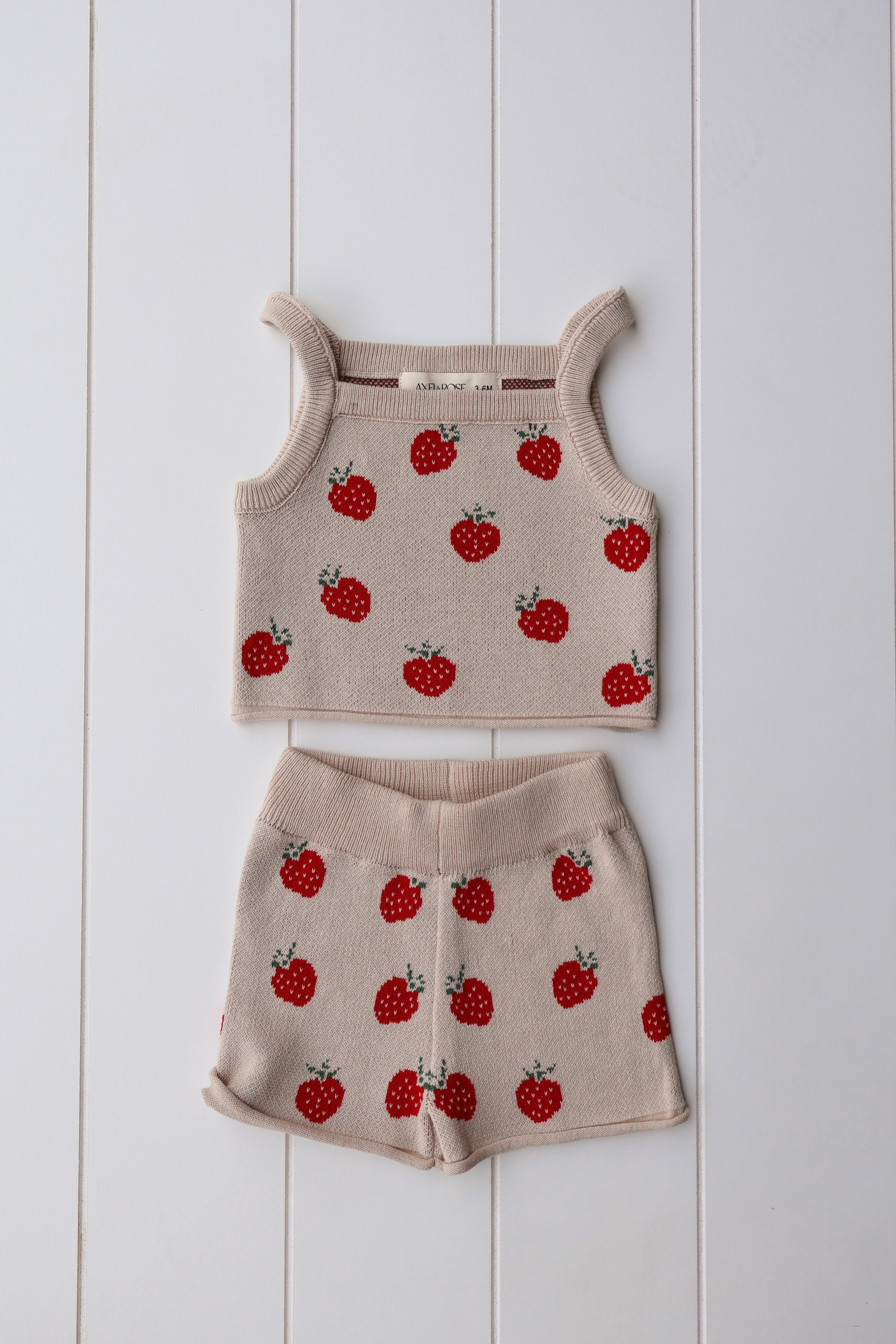 Spring knit strawberry two-piece set for baby girls, featuring a soft crop top and shorts with cute strawberry patterns.
